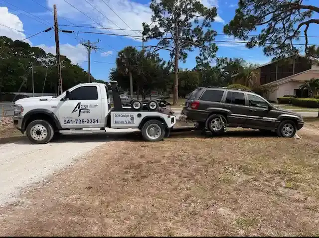 Action Towing wrecker hooked to a Jeep on a private property impound